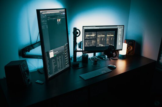Dos pantallas de ordenador sobre un escritorio.